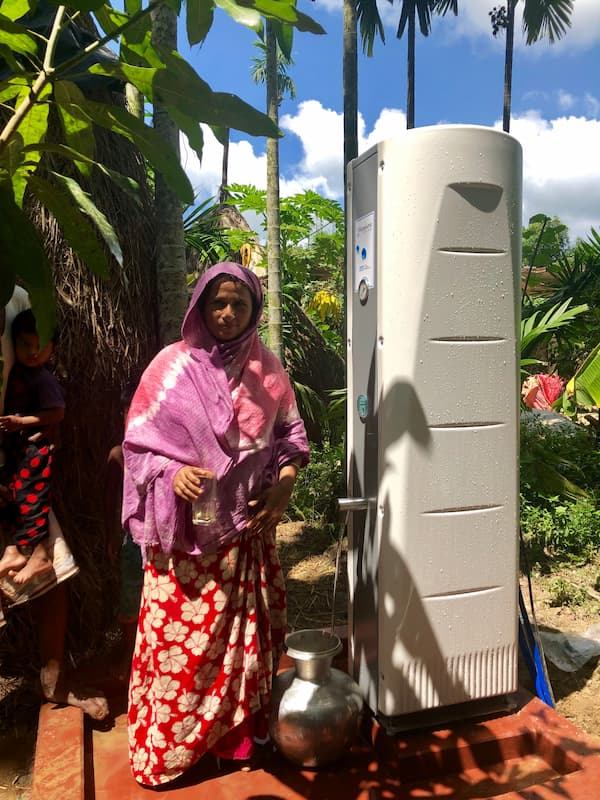 A woman collecting water from a Villagepump 500 Electric